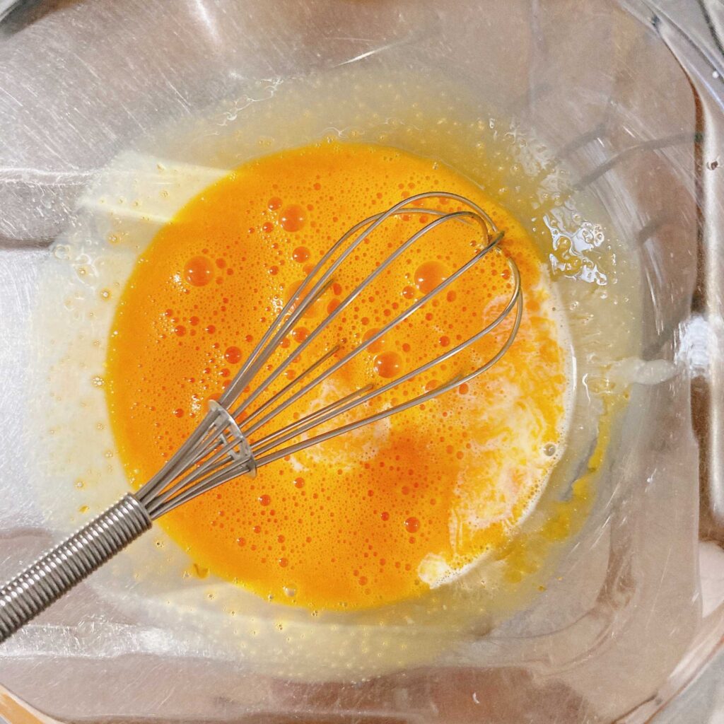 溶いた卵黄に生クリーム液を混ぜ入れる