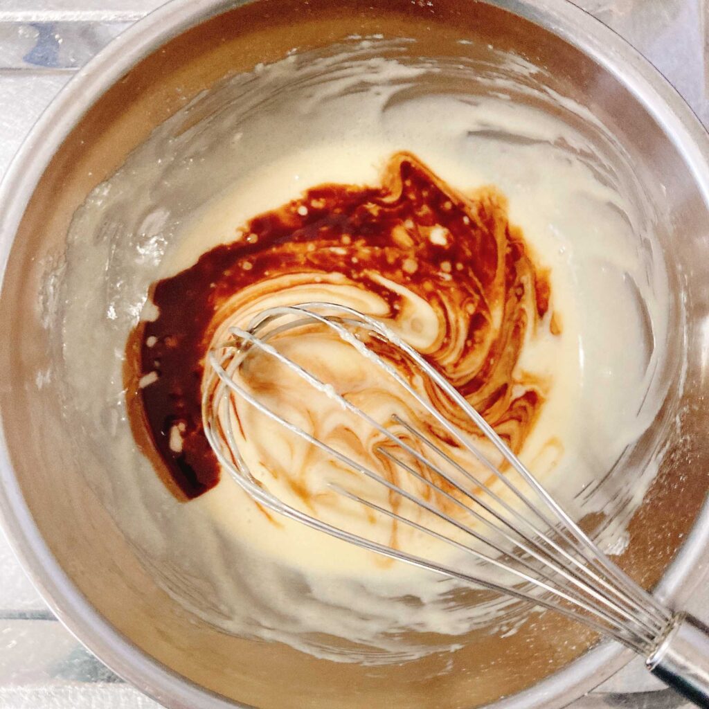 チョコとバターを溶かしたものを卵白側に加えて混ぜる